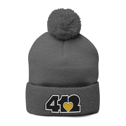 Cozy 412 Tossle Cap | Embroidered Black and Yellow Logo. Apparel Color: Dark Heather Grey. Has soft acrylic knit, fold-over cuff, and one-size fit for winter comfort.
