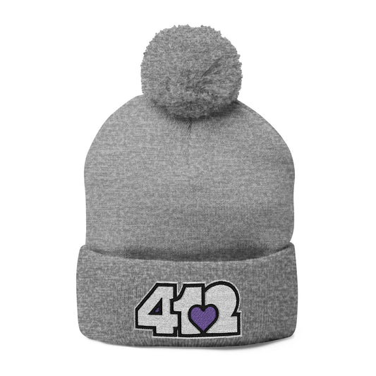 Cozy 412 Tossle Cap | Embroidered White and Purple Logo. Apparel Color: Heather Grey. Has soft acrylic knit, fold-over cuff, and one-size fit for winter comfort.