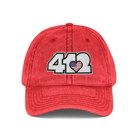 Pittsburgh Vintage Hat | Embroidered White Stars and Stripes 412 Logo. Apparel Color: Red. A relaxed fit, cotton twill fabric, adjustable buckle, and washed-out finish look.