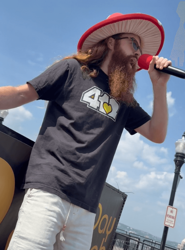 Fungi Flows Meets Purpose at a vibrant event featuring a speaker in a unique mushroom hat, engaging the crowd.