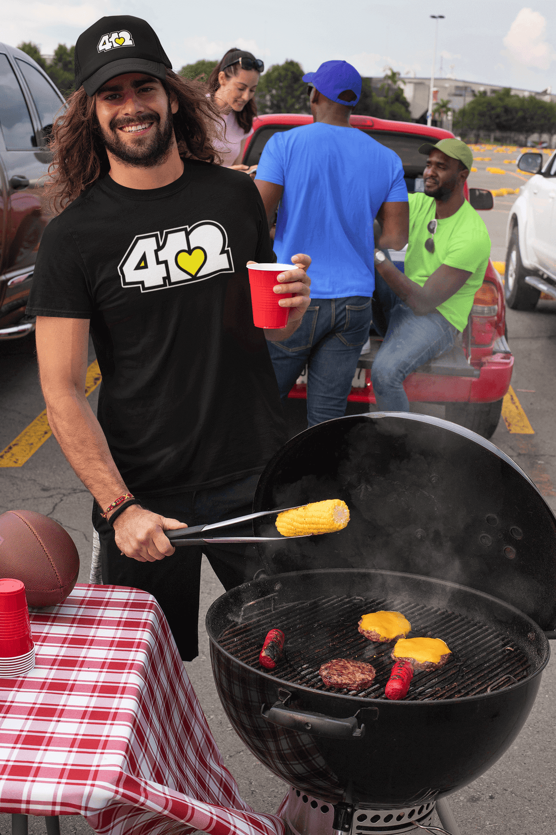 Introducing a man grilling while wearing 4OneLove2 apparel, enjoying a fun outdoor gathering.