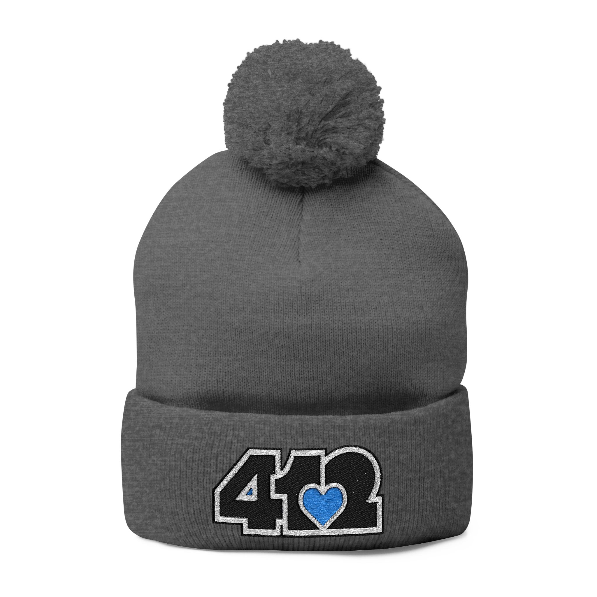 Cozy 412 Tossle Cap | Embroidered Black and Blue Logo. Apparel Color: Dark Heather Grey. Has soft acrylic knit, fold-over cuff, and one-size fit for winter comfort.