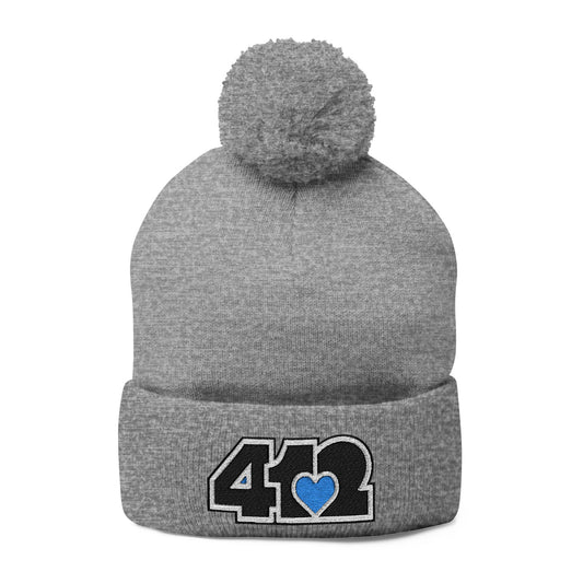 Cozy 412 Tossle Cap | Embroidered Black and Blue Logo. Apparel Color: Heather Grey. Has soft acrylic knit, fold-over cuff, and one-size fit for winter comfort.