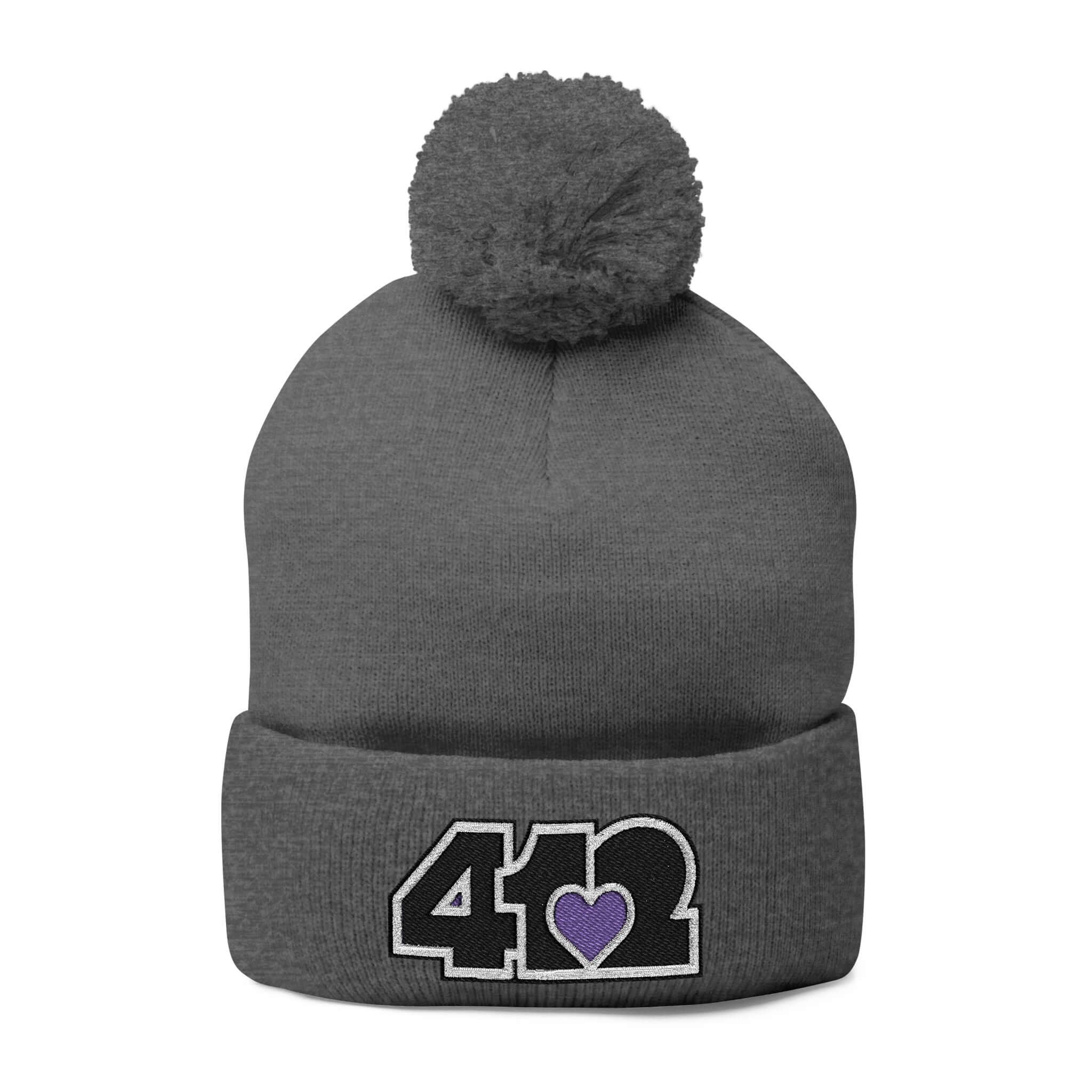 Cozy 412 Tossle Cap | Embroidered Black and Purple Logo. Apparel Color: Dark Heather Grey. Has soft acrylic knit, fold-over cuff, and one-size fit for winter comfort.