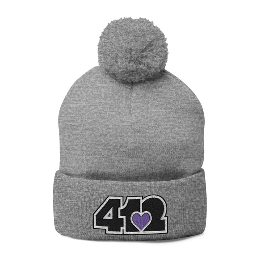 Cozy 412 Tossle Cap | Embroidered Black and Purple Logo. Apparel Color: Heather Grey. Has soft acrylic knit, fold-over cuff, and one-size fit for winter comfort.