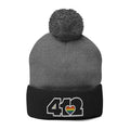 Cozy 412 Tossle Cap | Embroidered Black and Rainbow Logo. Apparel Color: Dark Heather Grey / Black. Has soft acrylic knit, fold-over cuff, and one-size fit for winter comfort.