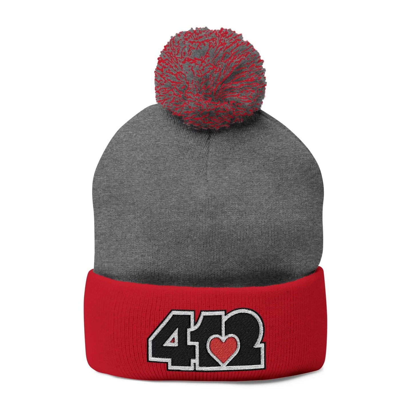 Cozy 412 Tossle Cap | Embroidered Black and Red Logo. Apparel Color: Dark Heather Grey / Red. Has soft acrylic knit, fold-over cuff, and one-size fit for winter comfort.