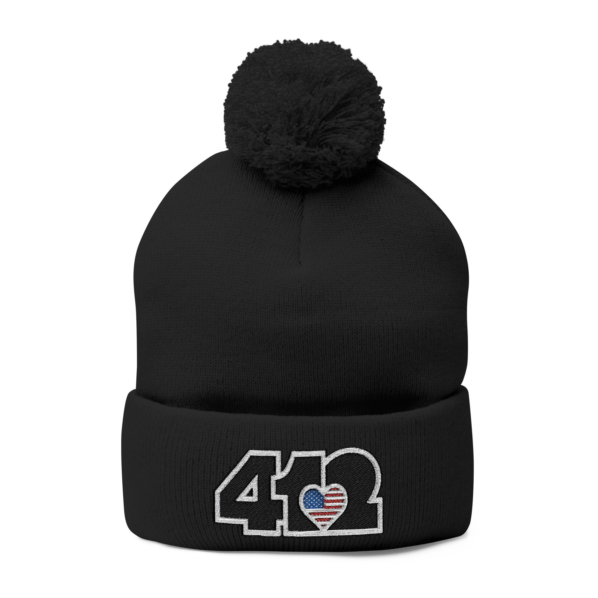412 Tossle Cap | Embroidered Stars & Stripes Black Logo. Apparel Color: Black. Has soft acrylic knit, fold-over cuff, and one-size fit for winter comfort.