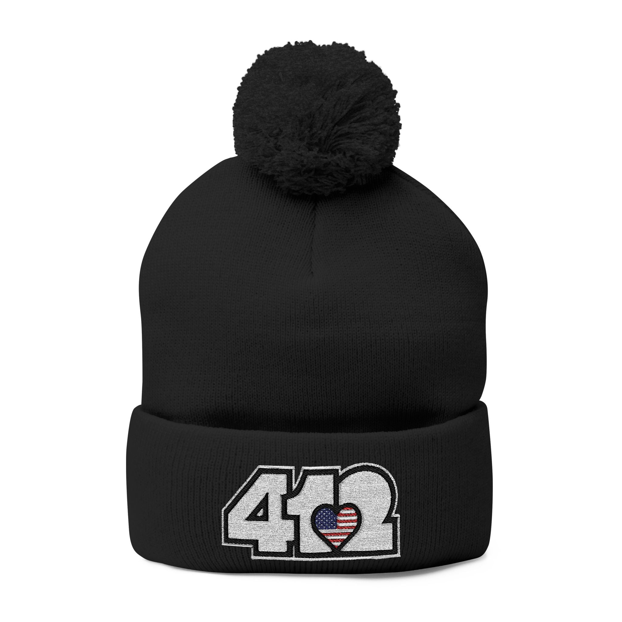 412 Tossle Cap | Embroidered Stars & Stripes White Logo. Apparel Color: Black. Has soft acrylic knit, fold-over cuff, and one-size fit for winter comfort.