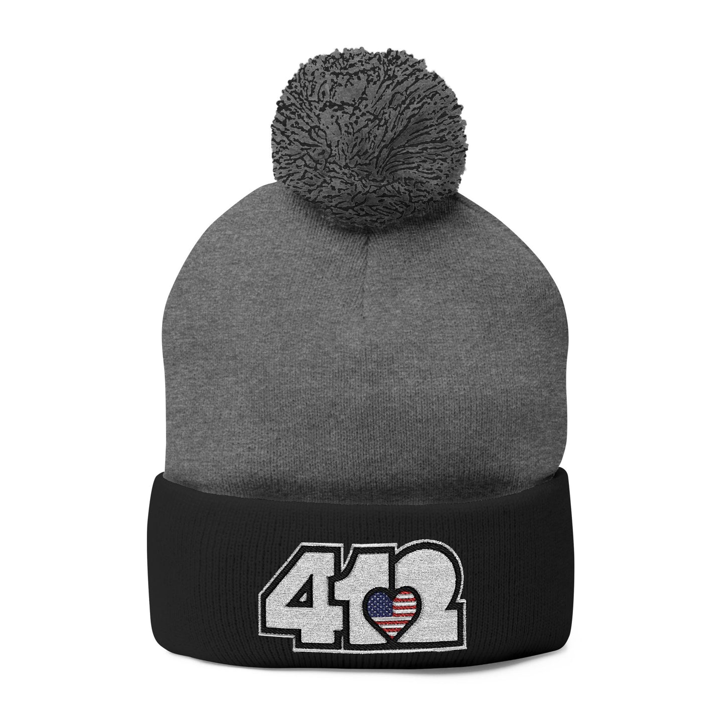 Cozy 412 Tossle Cap | Embroidered Stars & Stripes White Logo. Apparel Color: Dark Heather Grey / Black. Has soft acrylic knit, fold-over cuff, and one-size fit for winter comfort.
