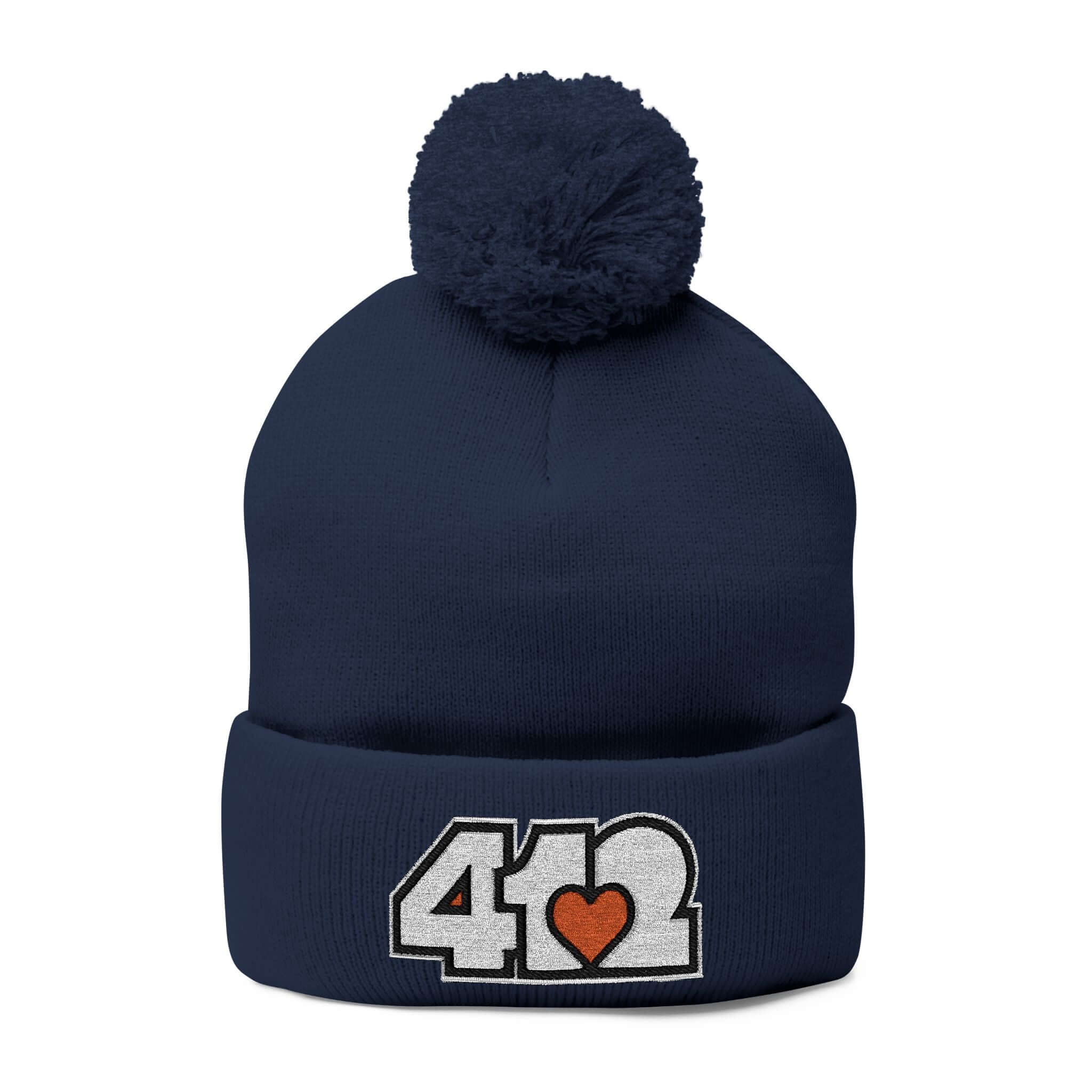 Cozy 412 Tossle Cap | Embroidered White and Orange Logo. Apparel Color: Navy. Has soft acrylic knit, fold-over cuff, and one-size fit for winter comfort.