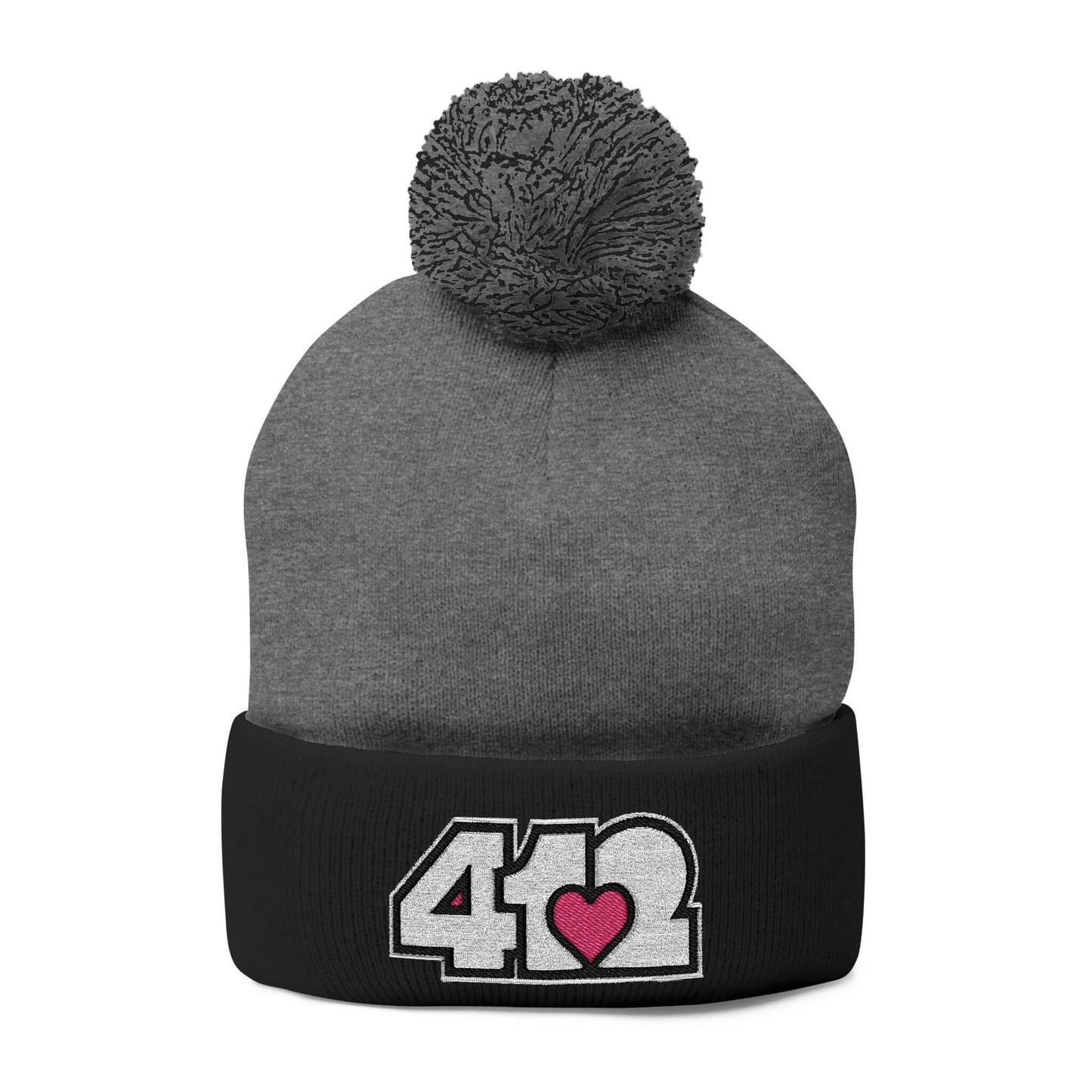 Cozy 412 Tossle Cap | Embroidered White and Pink Logo. Apparel Color: Dark Heather Grey / Black. Has soft acrylic knit, fold-over cuff, and one-size fit for winter comfort.