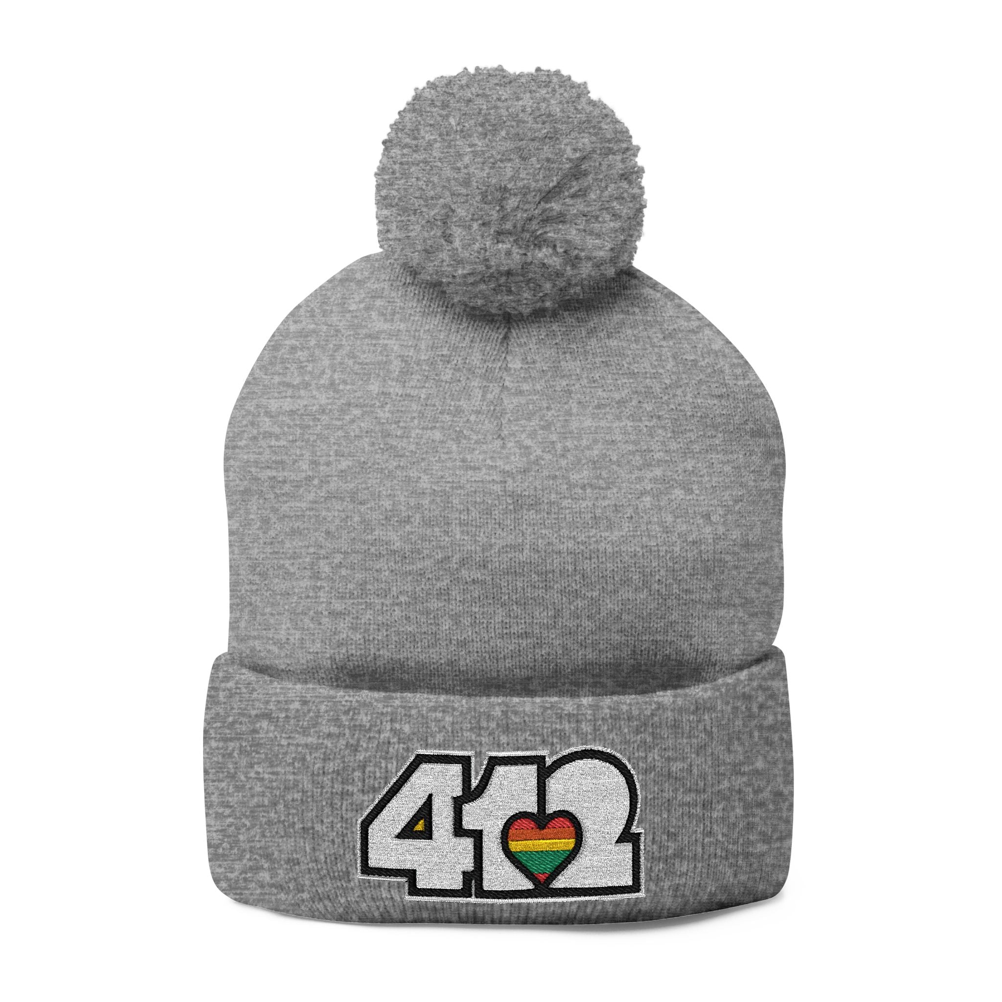412 Tossle Cap | Embroidered White and Rainbow Logo. Apparel Color: Heather Grey. Has soft acrylic knit, fold-over cuff, and one-size fit for winter comfort.