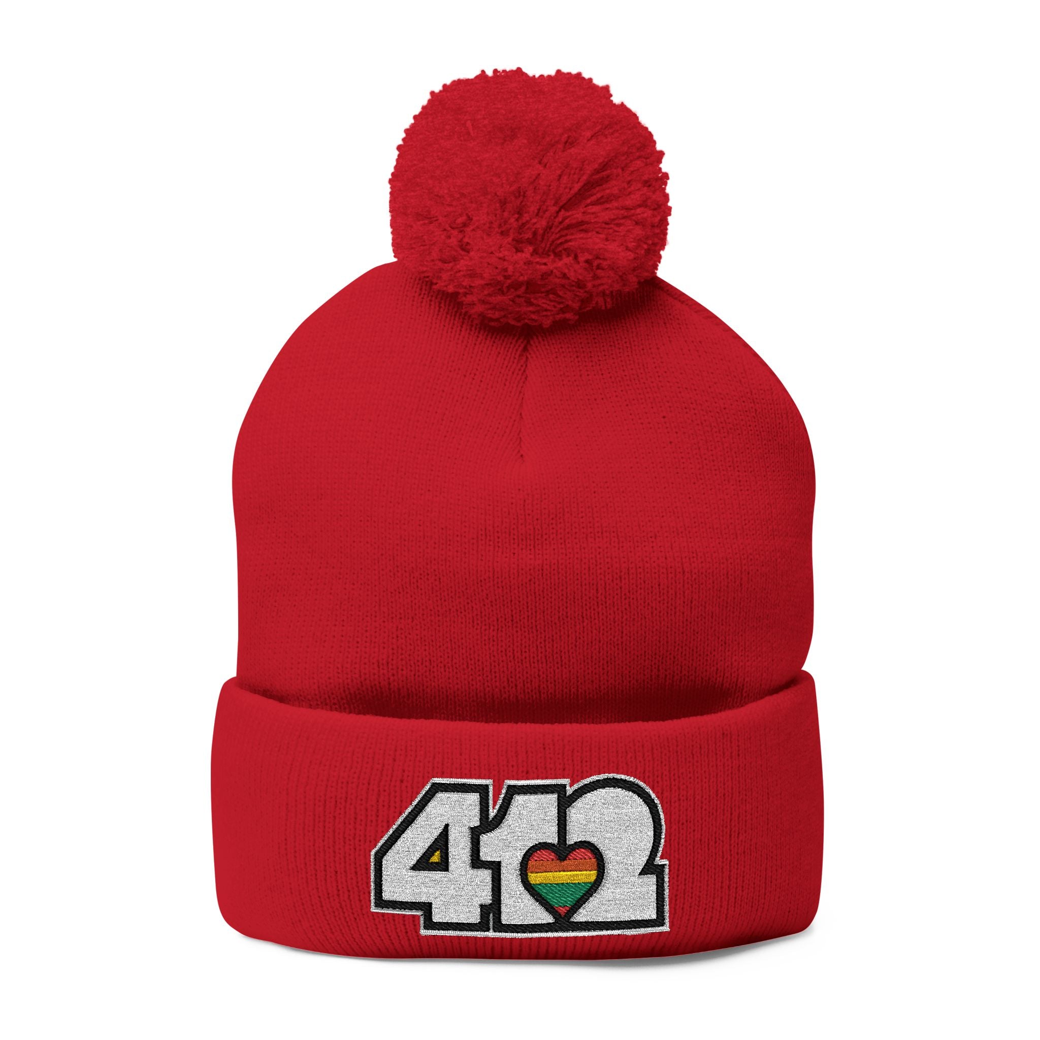 412 Tossle Cap | Embroidered White and Rainbow Logo. Apparel Color: Red. Has soft acrylic knit, fold-over cuff, and one-size fit for winter comfort.
