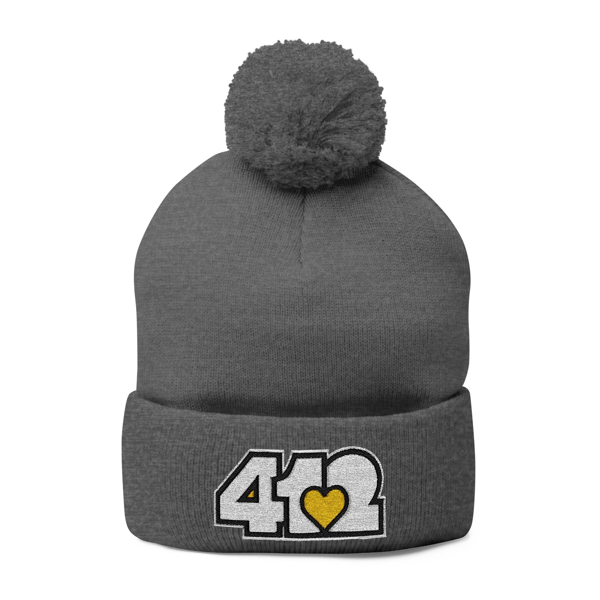 Cozy 412 Tossle Cap | Embroidered White and Yellow Logo. Apparel Color: Dark Heather Grey. Has soft acrylic knit, fold-over cuff, and one-size fit for winter comfort.
