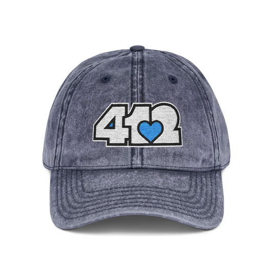 Pittsburgh Vintage Hat | Embroidered White and Blue 412 Logo. Apparel Color: Navy. A relaxed fit, cotton twill fabric, adjustable buckle, and washed-out finish look.