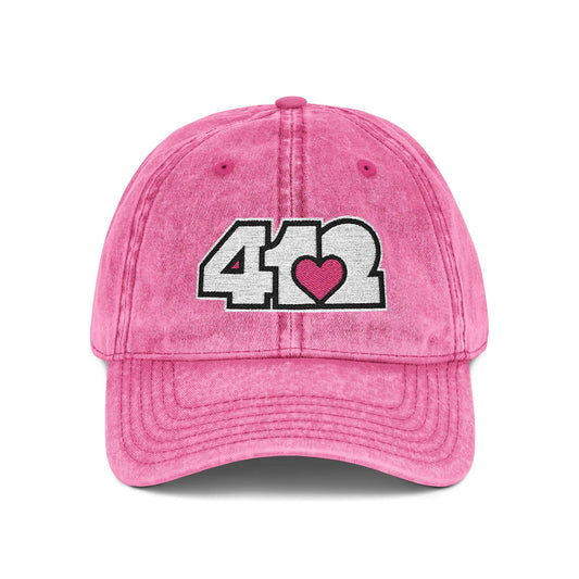 Pittsburgh Vintage Hat | Embroidered White and Pink 412 Logo. Apparel Color: Pink. A relaxed fit, cotton twill fabric, adjustable buckle, and washed-out finish look.