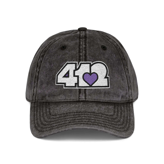 Pittsburgh Vintage Hat | Embroidered White and Purple 412 Logo. Apparel Color: Black. A relaxed fit, cotton twill fabric, adjustable buckle, and washed-out finish look.
