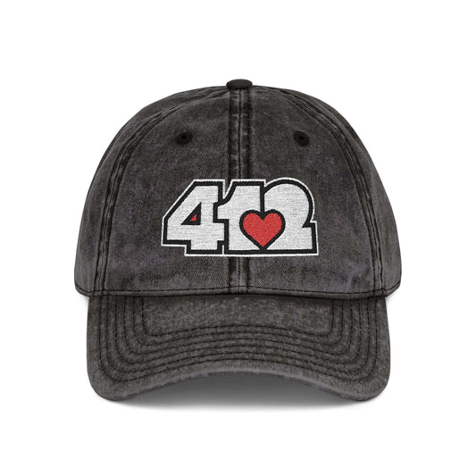 Pittsburgh Vintage Hat | Embroidered White and Red 412 Logo. Apparel Color: Black. A relaxed fit, cotton twill fabric, adjustable buckle, and washed-out finish look.