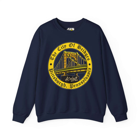 The City of Bridges Sweatshirt. Apparel Color: Navy. A blend of 50% cotton and 50% polyester for cozy durability. With an Elastic ribbed collar, and Double-needle stitching.
