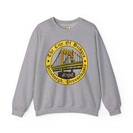 The City of Bridges Sweatshirt. Apparel Color: Sport Grey. A blend of 50% cotton and 50% polyester for cozy durability. With an Elastic ribbed collar, and Double-needle stitching.